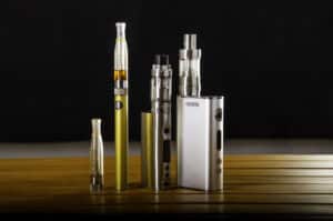 Popular vaping e cig devices mod.electronic cigarette over a wood background. vaporizer e-cig old device model.