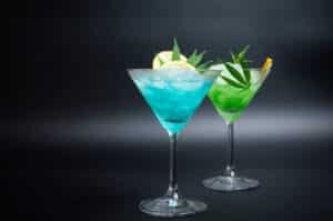 Two different cocktails - green and blue, with marijuana, refreshing lemon and lots of ice